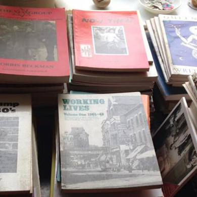 An overhead view of several stacks of historic magazines, books, and other forms of publications.